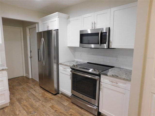 15916 Marshfield Dr, Tampa, FL 33624 - kitchen featuring appliances with stainless steel finishes, backsplash, light wood-style flooring, white cabinets, and light stone counters