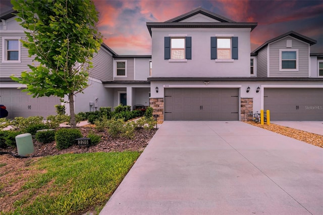 3216 Bryant Park Dr, New Port Richey, FL 34655 - view of front facade with stone siding, stucco siding, a garage, and driveway