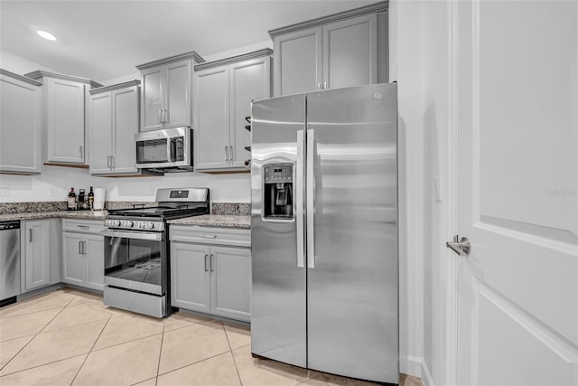 3216 Bryant Park Dr, New Port Richey, FL 34655 - kitchen featuring stainless steel appliances, gray cabinetry, light stone counters, and light tile patterned floors