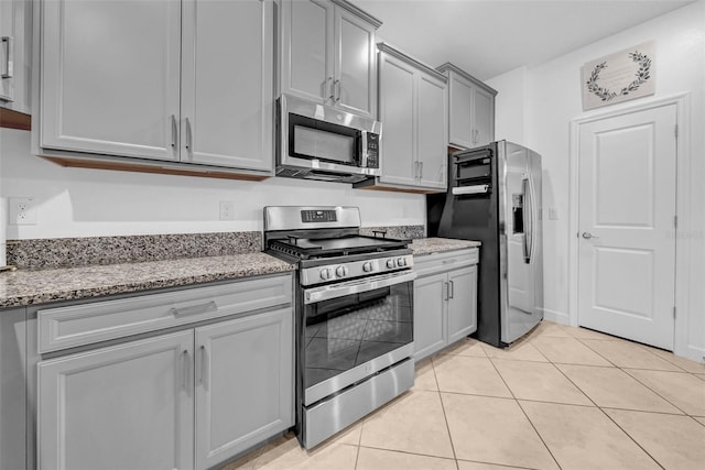 3216 Bryant Park Dr, New Port Richey, FL 34655 - kitchen featuring stainless steel appliances, gray cabinetry, light tile patterned floors, and light stone counters