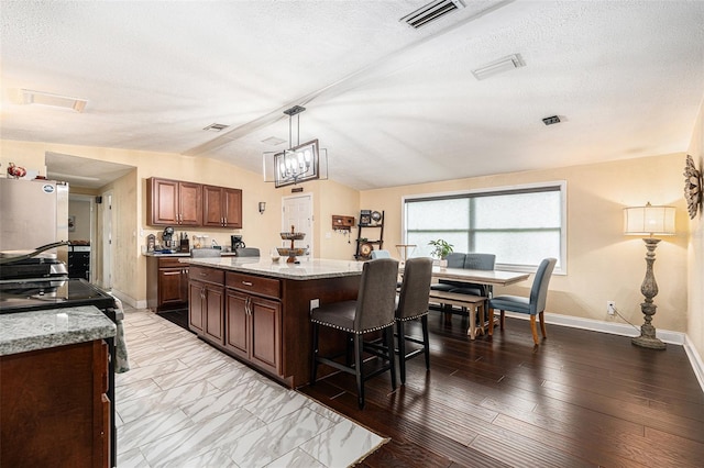 9220 Mcintosh Rd, Dover, FL 33527 - kitchen featuring a breakfast bar, vaulted ceiling, a kitchen island, stove, and light stone countertops