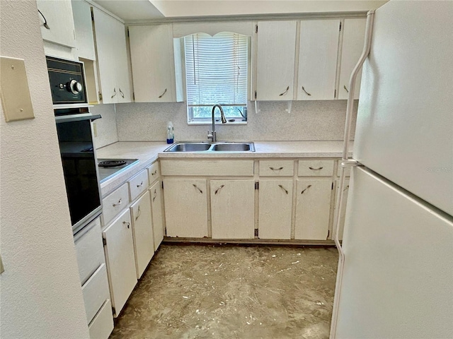 2391 Sumatran Way Unit 37, Clearwater, FL 33763 - kitchen with freestanding refrigerator, a sink, light countertops, oven, and unfinished concrete flooring