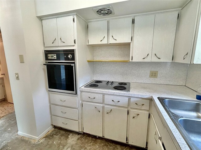 2391 Sumatran Way Unit 37, Clearwater, FL 33763 - kitchen featuring black oven, stainless steel electric cooktop, light countertops, unfinished concrete flooring, and a sink