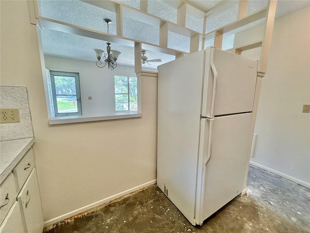 2391 Sumatran Way Unit 37, Clearwater, FL 33763 - kitchen featuring freestanding refrigerator, baseboards, a chandelier, light countertops, and unfinished concrete floors