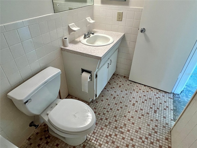 2391 Sumatran Way Unit 37, Clearwater, FL 33763 - bathroom featuring tile walls, vanity, toilet, tile patterned flooring, and a wainscoted wall