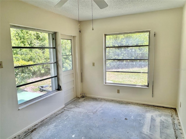 2391 Sumatran Way Unit 37, Clearwater, FL 33763 - spare room with healthy amount of natural light, a textured ceiling, a ceiling fan, and baseboards