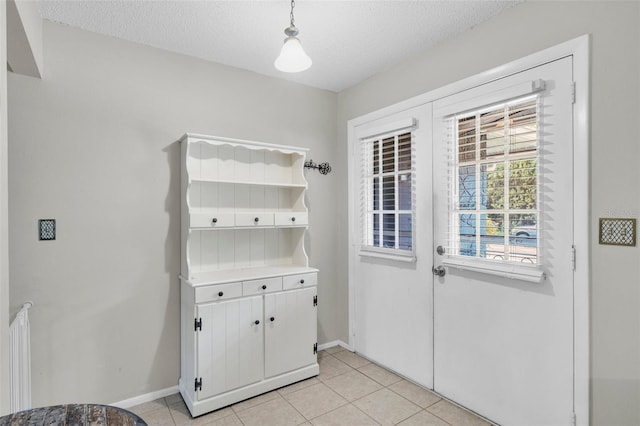 7708 Fairlawn Dr, Hudson, FL 34667 - doorway with light tile patterned floors, baseboards, and a textured ceiling