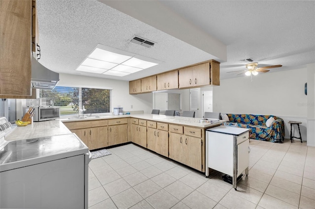 7708 Fairlawn Dr, Hudson, FL 34667 - kitchen with range, wall chimney exhaust hood, a textured ceiling, light countertops, and stainless steel microwave