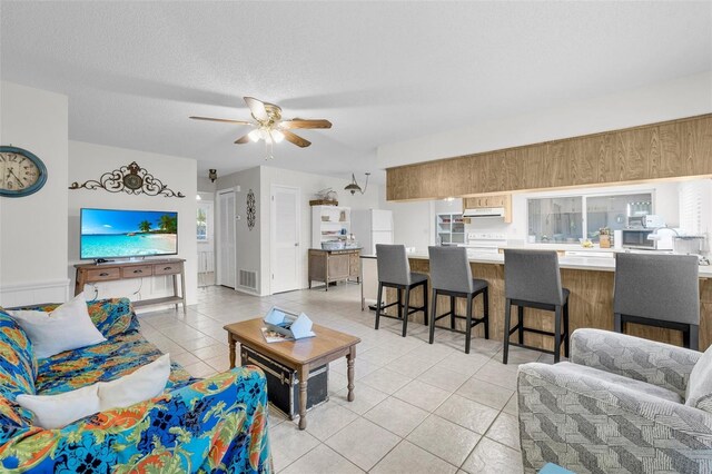 7708 Fairlawn Dr, Hudson, FL 34667 - living room featuring light tile patterned floors, ceiling fan, and a textured ceiling