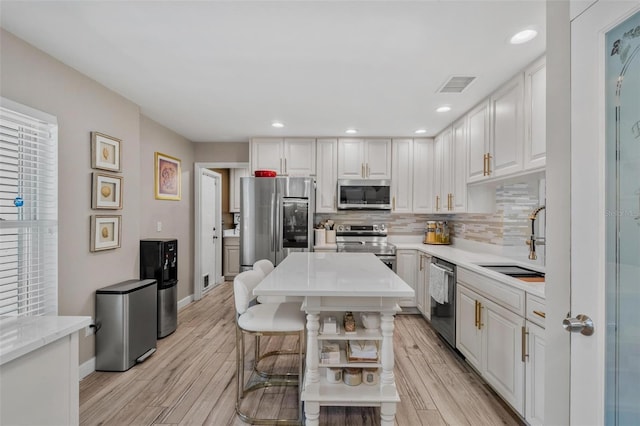 2824 Paddock Dr, Palm Harbor, FL 34684 - kitchen featuring stainless steel appliances, a sink, backsplash, light countertops, and light wood-style floors