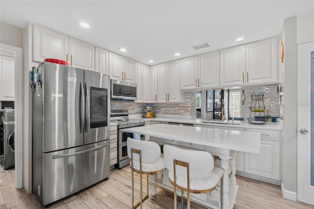 2824 Paddock Dr, Palm Harbor, FL 34684 - kitchen featuring appliances with stainless steel finishes, light countertops, decorative backsplash, light wood finished floors, and a sink