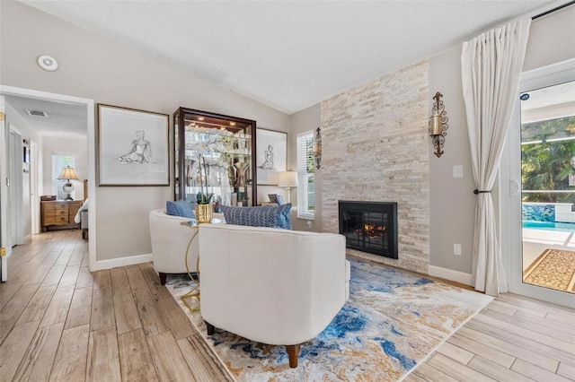 2824 Paddock Dr, Palm Harbor, FL 34684 - living area with a fireplace, wood finished floors, vaulted ceiling, baseboards, and a textured ceiling