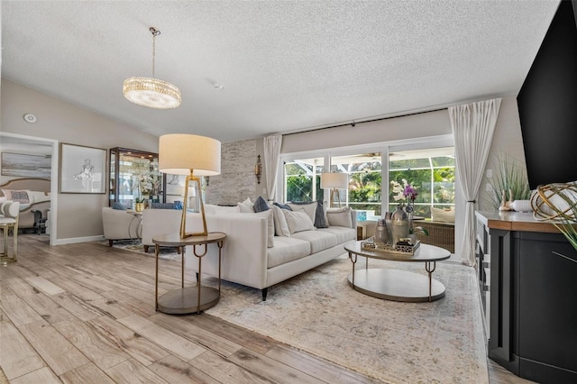 2824 Paddock Dr, Palm Harbor, FL 34684 - living area with a textured ceiling, light wood finished floors, a chandelier, lofted ceiling, and baseboards