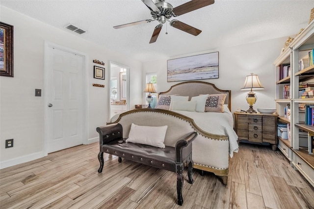 2824 Paddock Dr, Palm Harbor, FL 34684 - bedroom with wood finished floors, a textured ceiling, ensuite bathroom, baseboards, and a ceiling fan
