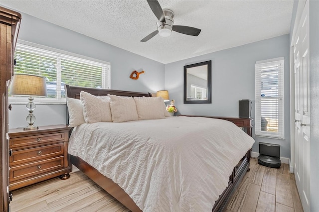 2824 Paddock Dr, Palm Harbor, FL 34684 - bedroom featuring a textured ceiling, light wood-style flooring, baseboards, and ceiling fan