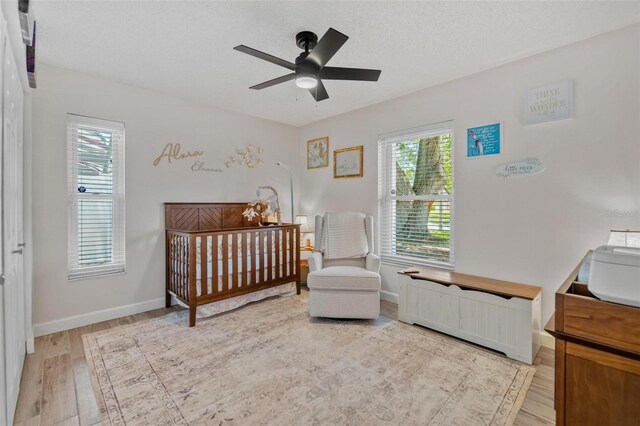 2824 Paddock Dr, Palm Harbor, FL 34684 - bedroom with multiple windows, light wood-style floors, baseboards, and ceiling fan