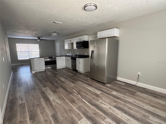 1215 Windsor Cir, Brandon, FL 33510 - kitchen featuring stainless steel appliances, baseboards, a textured ceiling, a peninsula, and dark wood finished floors