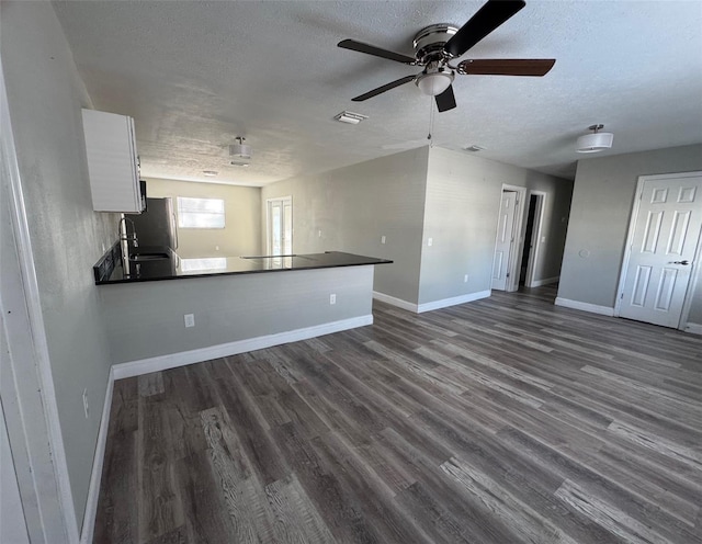 1215 Windsor Cir, Brandon, FL 33510 - unfurnished living room with a textured ceiling, a ceiling fan, dark wood-style floors, and baseboards