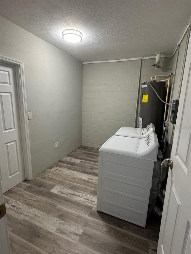 1215 Windsor Cir, Brandon, FL 33510 - laundry room with a textured ceiling, concrete block wall, water heater, washer / clothes dryer, and wood finished floors