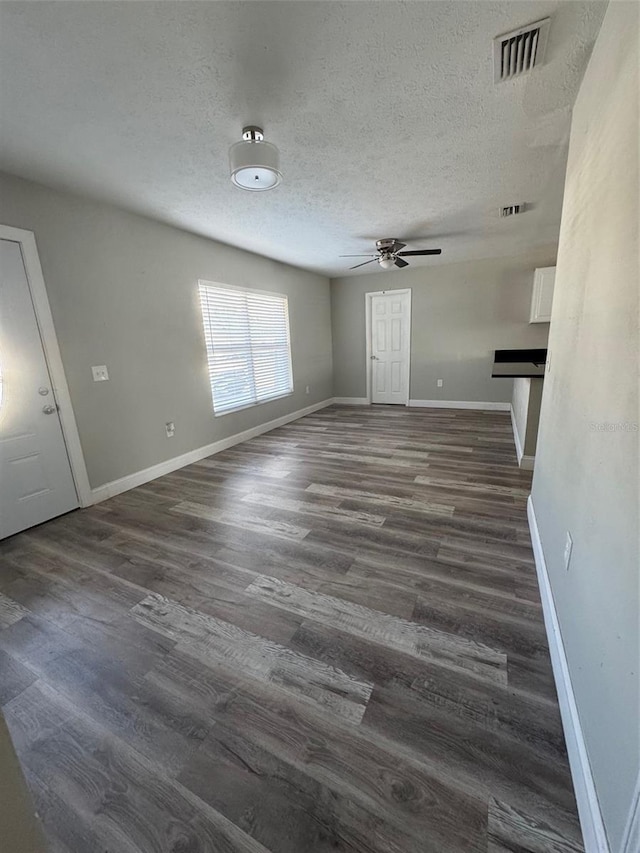 1215 Windsor Cir, Brandon, FL 33510 - unfurnished living room featuring ceiling fan, dark wood-type flooring, a textured ceiling, and baseboards