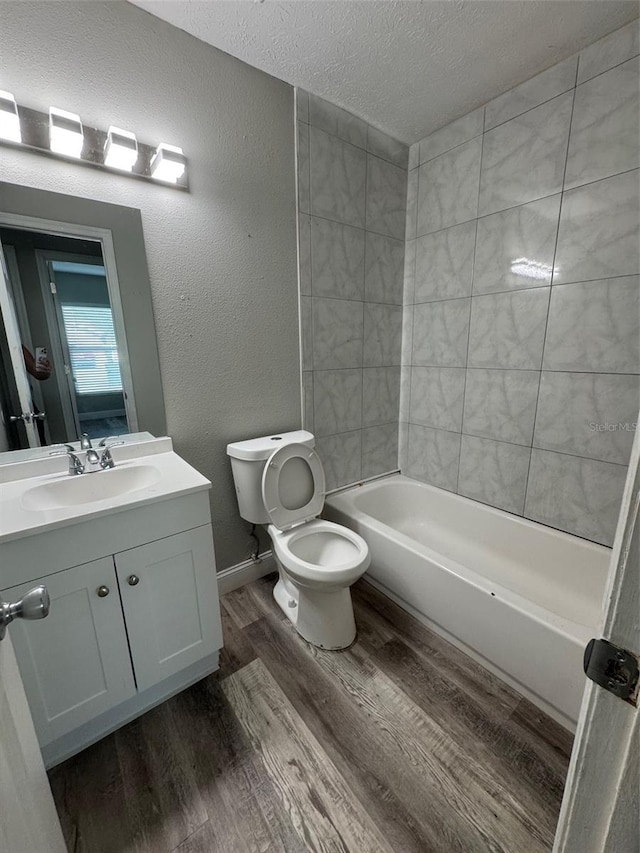 1215 Windsor Cir, Brandon, FL 33510 - full bathroom with toilet, wood finished floors, vanity, a textured ceiling, and bathtub / shower combination