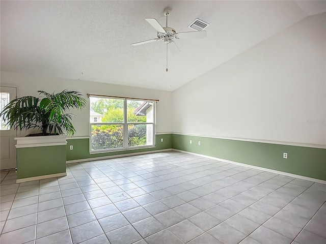 8822 Misty Creek Dr, Sarasota, FL 34241 - empty room with lofted ceiling, tile patterned flooring, ceiling fan, baseboards, and a textured ceiling