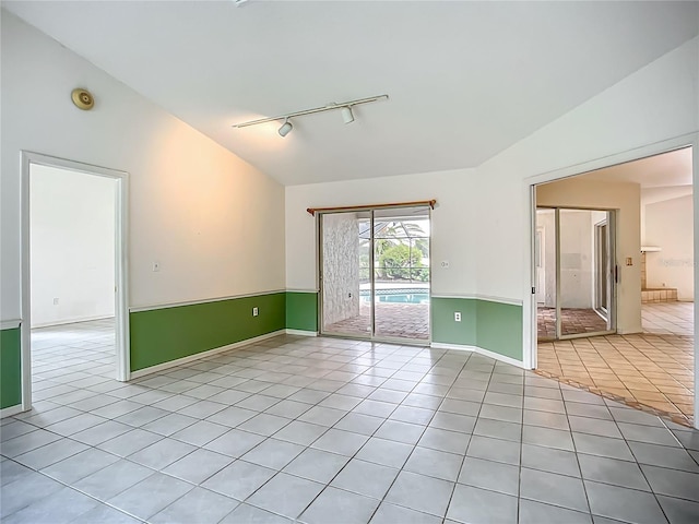 8822 Misty Creek Dr, Sarasota, FL 34241 - empty room with track lighting, light tile patterned floors, vaulted ceiling, baseboards, and a smoke detector
