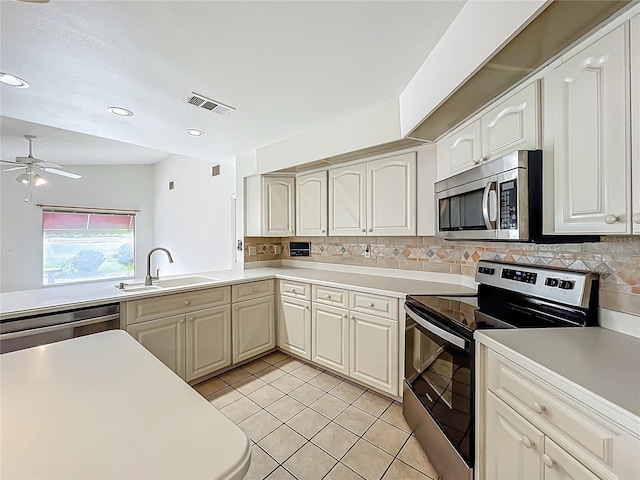 8822 Misty Creek Dr, Sarasota, FL 34241 - kitchen featuring appliances with stainless steel finishes, a sink, decorative backsplash, light tile patterned floors, and recessed lighting