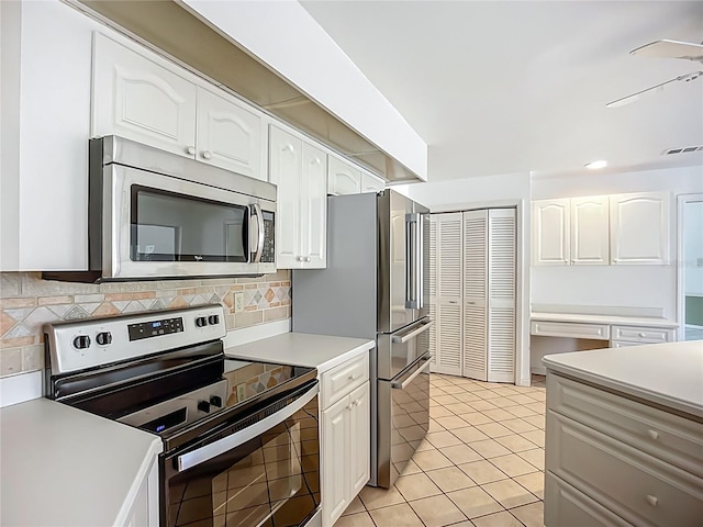 8822 Misty Creek Dr, Sarasota, FL 34241 - kitchen featuring stainless steel appliances, white cabinetry, light countertops, tasteful backsplash, and light tile patterned flooring