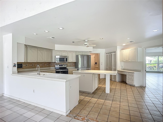 8822 Misty Creek Dr, Sarasota, FL 34241 - kitchen featuring stainless steel appliances, a sink, backsplash, a kitchen island, and a peninsula