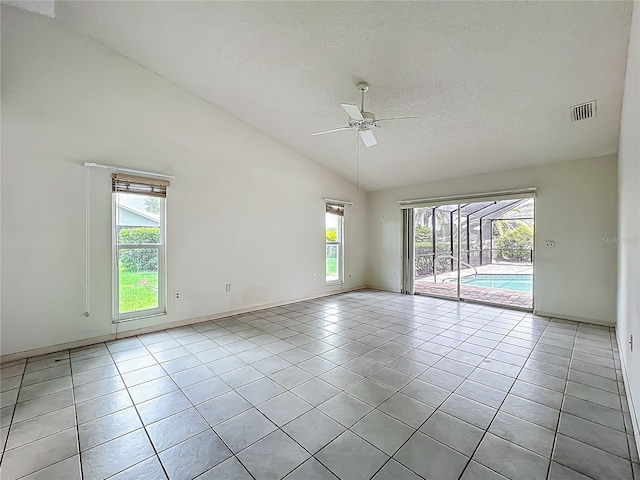 8822 Misty Creek Dr, Sarasota, FL 34241 - spare room featuring vaulted ceiling, light tile patterned floors, plenty of natural light, a ceiling fan, and a textured ceiling