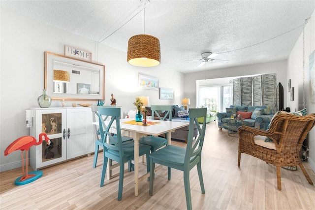 2060 Marilyn St Unit 114, Clearwater, FL 33765 - dining area with a textured ceiling, light wood-type flooring, a ceiling fan, and baseboards