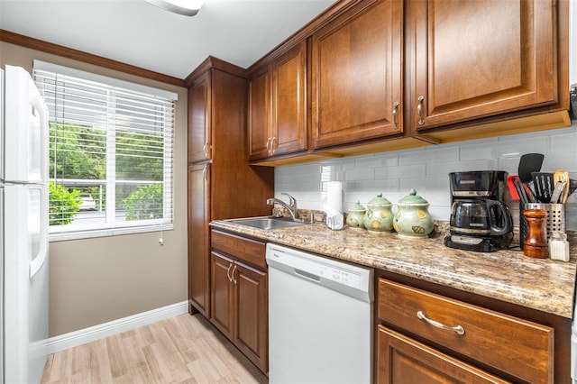 2060 Marilyn St Unit 114, Clearwater, FL 33765 - kitchen featuring white appliances, a sink, baseboards, backsplash, and light wood-style flooring