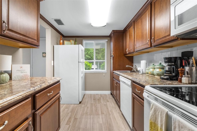 2060 Marilyn St Unit 114, Clearwater, FL 33765 - kitchen with white appliances, a sink, decorative backsplash, light wood finished floors, and baseboards