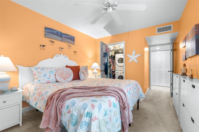 2060 Marilyn St Unit 114, Clearwater, FL 33765 - bedroom with stacked washer / dryer, light carpet, baseboards, a closet, and a textured ceiling