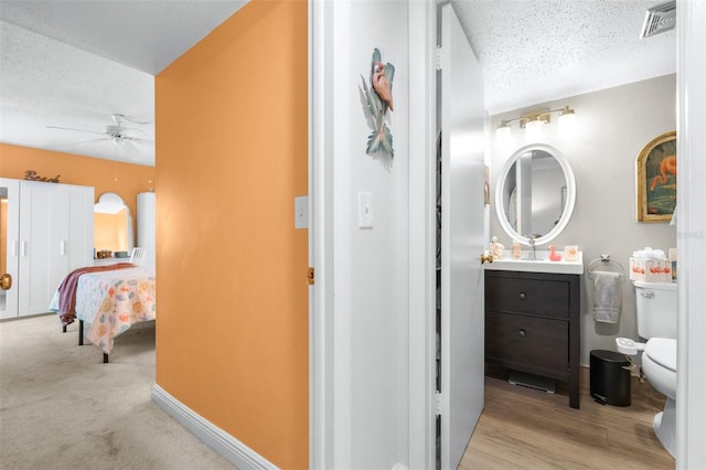 2060 Marilyn St Unit 114, Clearwater, FL 33765 - bathroom featuring toilet, a textured ceiling, vanity, a ceiling fan, and baseboards