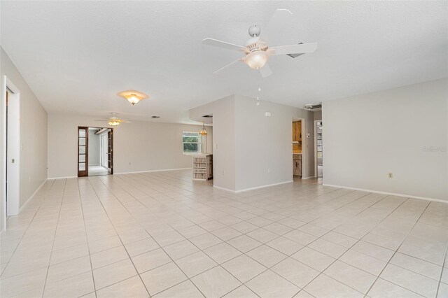 1839 Neptune Dr, Englewood, FL 34223 - unfurnished living room with a ceiling fan, light tile patterned floors, and baseboards