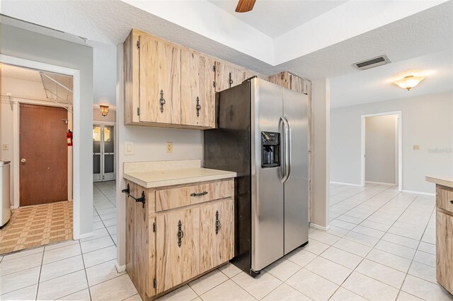 1839 Neptune Dr, Englewood, FL 34223 - kitchen with stainless steel fridge with ice dispenser, light tile patterned floors, light countertops, a ceiling fan, and a textured ceiling