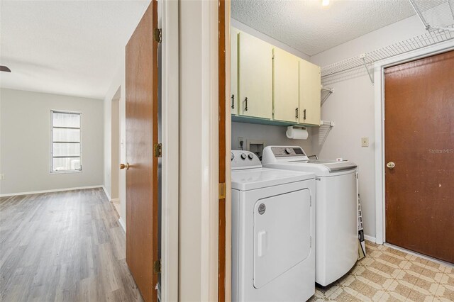 1839 Neptune Dr, Englewood, FL 34223 - washroom featuring cabinet space, washing machine and clothes dryer, light wood-style flooring, baseboards, and a textured ceiling