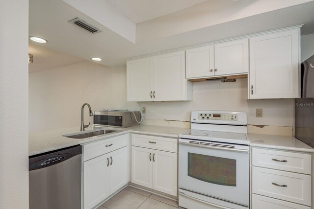 210 Martha Ln Unit 210, Oldsmar, FL 34677 - kitchen featuring stainless steel appliances, a sink, white cabinets, light countertops, and light tile patterned floors