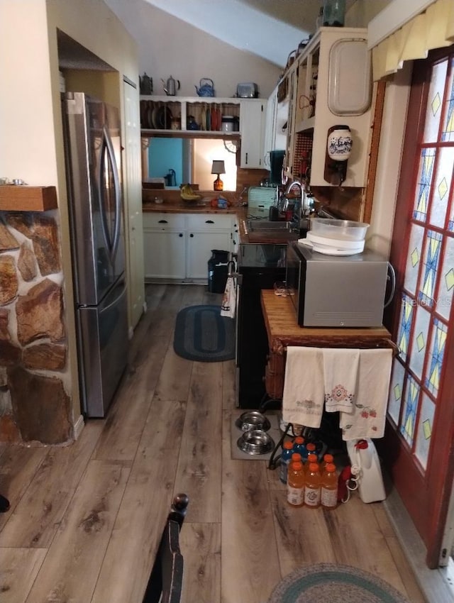 7608 Chenkin, Zephyrhills, FL 33540 - kitchen with freestanding refrigerator, a sink, hardwood / wood-style floors, vaulted ceiling, and white cabinetry