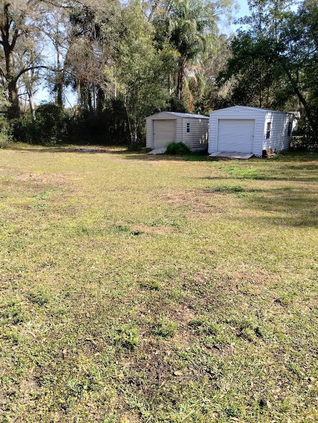 7608 Chenkin, Zephyrhills, FL 33540 - view of grassy yard with an outdoor structure, view of scattered trees, and a garage