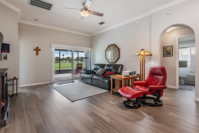 10232 Buncombe Way, San Antonio, FL 33576 - living area with arched walkways, a ceiling fan, wood finished floors, ornamental molding, and baseboards
