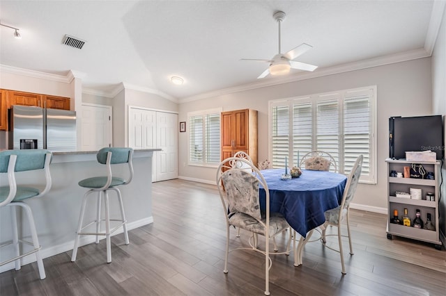 10232 Buncombe Way, San Antonio, FL 33576 - dining space with a ceiling fan, baseboards, wood finished floors, crown molding, and vaulted ceiling