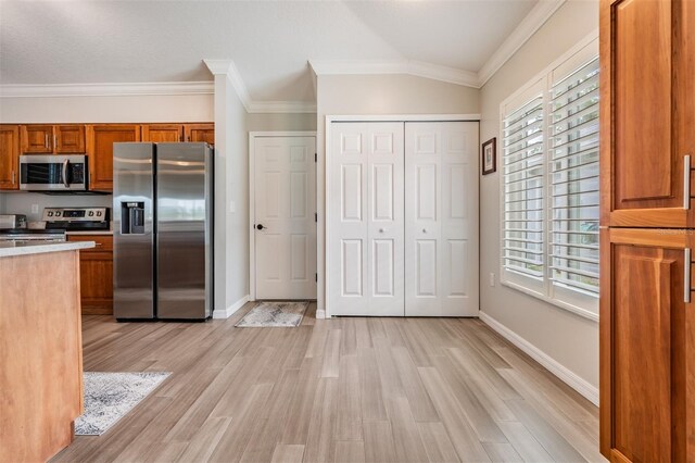 10232 Buncombe Way, San Antonio, FL 33576 - kitchen with stainless steel appliances, brown cabinets, light wood-type flooring, plenty of natural light, and crown molding
