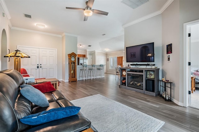 10232 Buncombe Way, San Antonio, FL 33576 - living area featuring wood finished floors, crown molding, a ceiling fan, and baseboards