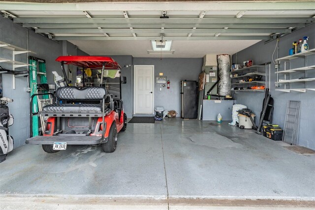 10232 Buncombe Way, San Antonio, FL 33576 - garage featuring freestanding refrigerator and a garage door opener