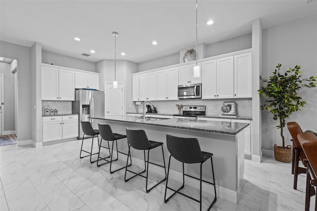 5742 Stockport St, Riverview, FL 33578 - kitchen featuring stainless steel appliances, a kitchen bar, light marble finish flooring, a kitchen island with sink, and recessed lighting