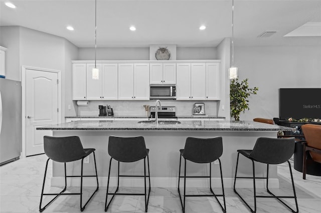 5742 Stockport St, Riverview, FL 33578 - kitchen with stainless steel appliances, light marble finish flooring, a breakfast bar, dark stone counters, and recessed lighting