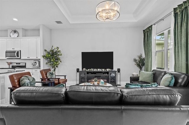 5742 Stockport St, Riverview, FL 33578 - living room featuring a chandelier, crown molding, and a tray ceiling